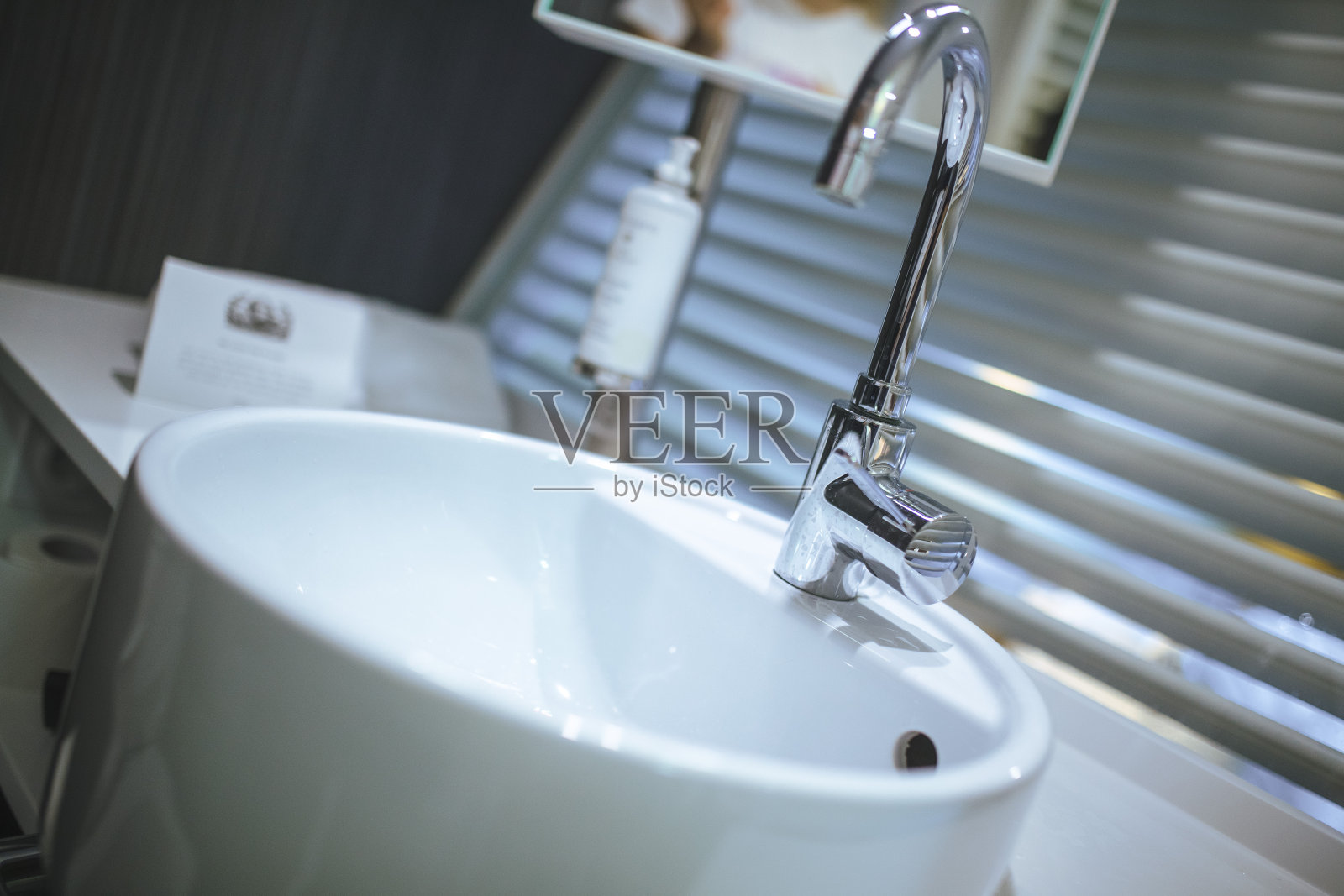 酒店浴室的水槽和水龙头的特写。照片摄影图片