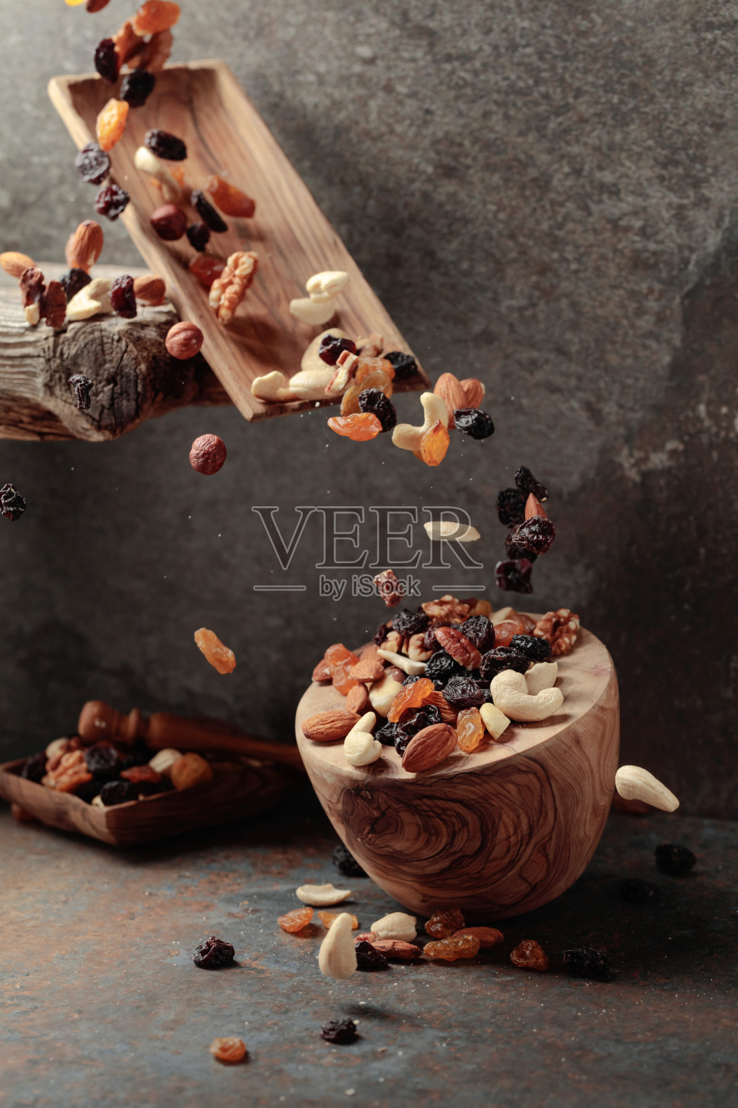 有坚果和葡萄干掉落的盘子。照片摄影图片