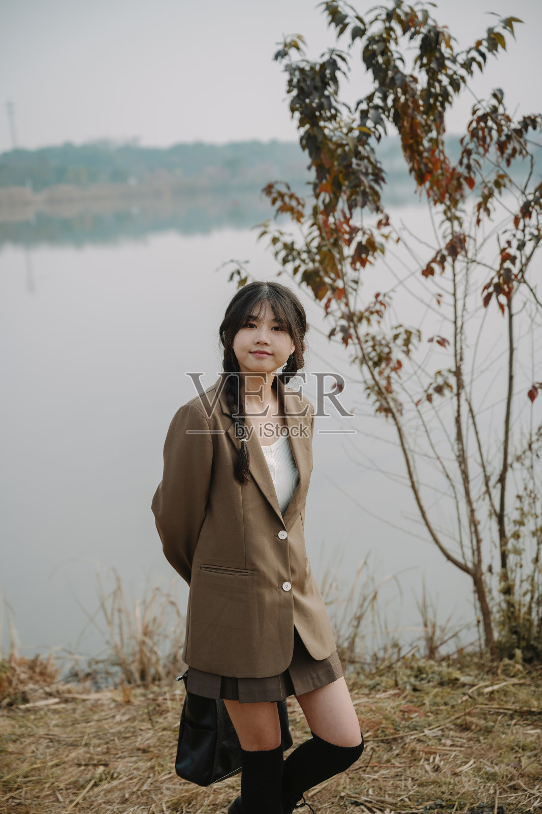 亚洲女大学生在阳光明媚的草地上快乐地玩耍照片摄影图片