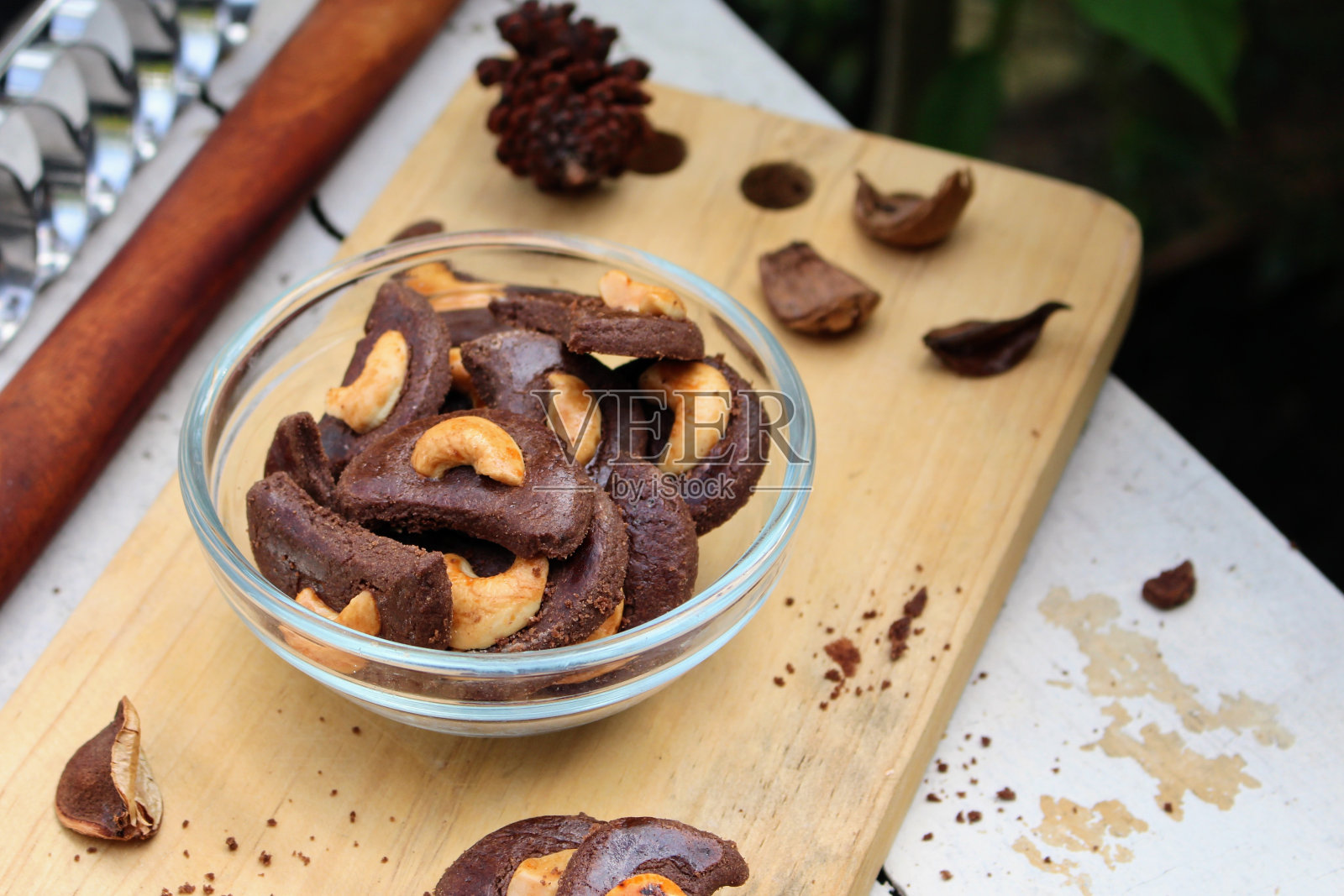 巧克力腰果饼干，装在透明的碗里，放在木盘上。照片摄影图片
