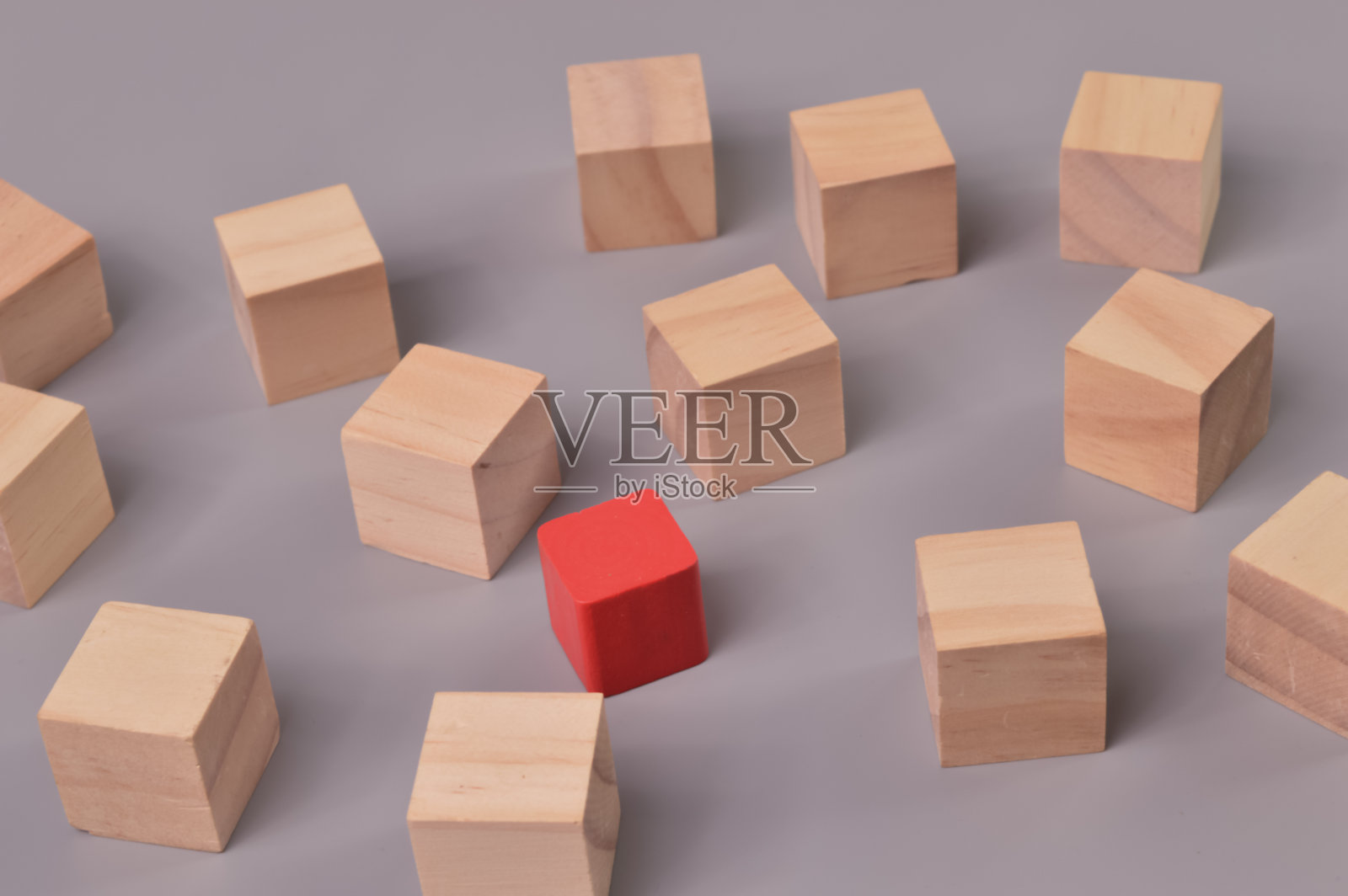 红色的木方块从木方块中脱颖而出。反对意见和领导理念照片摄影图片