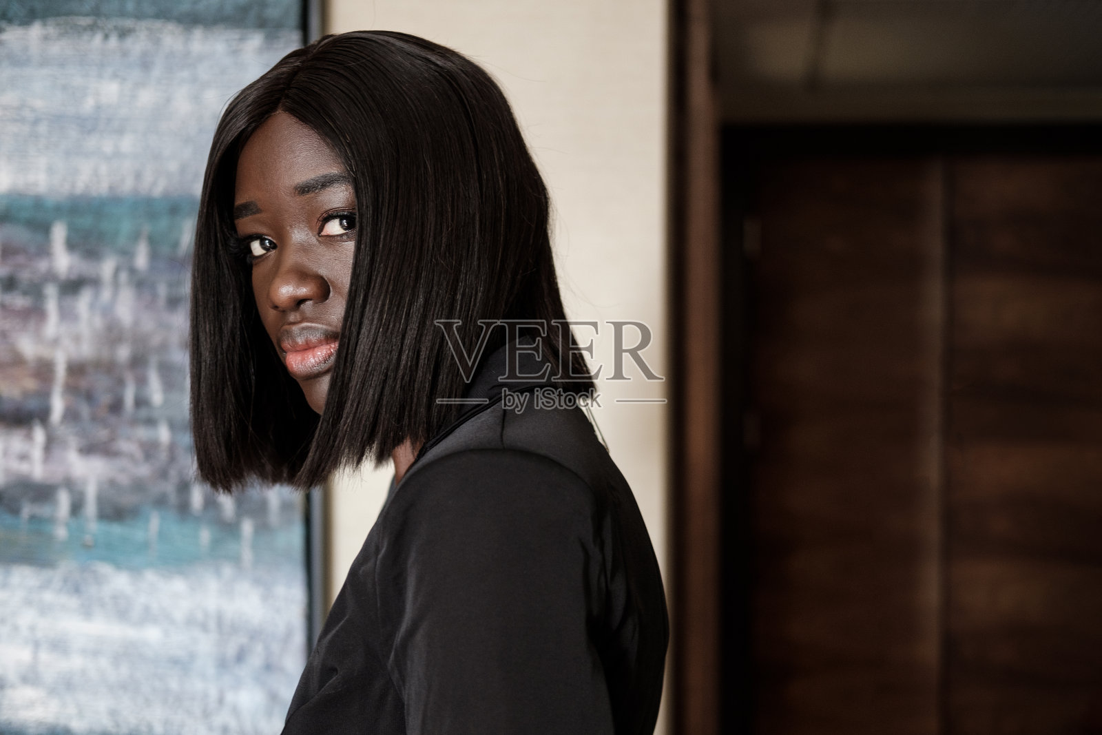 年轻的黑人妇女看着镜头。照片摄影图片