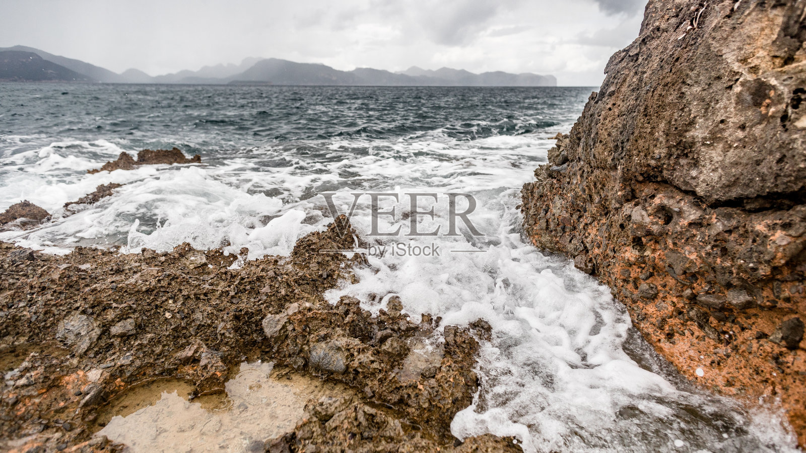 风景优美的地中海，巴利阿里群岛的阿尔库迪亚。西班牙,西班牙的风景。美丽的自然和山岩。天空乌云密布。周围的森林和沙子照片摄影图片