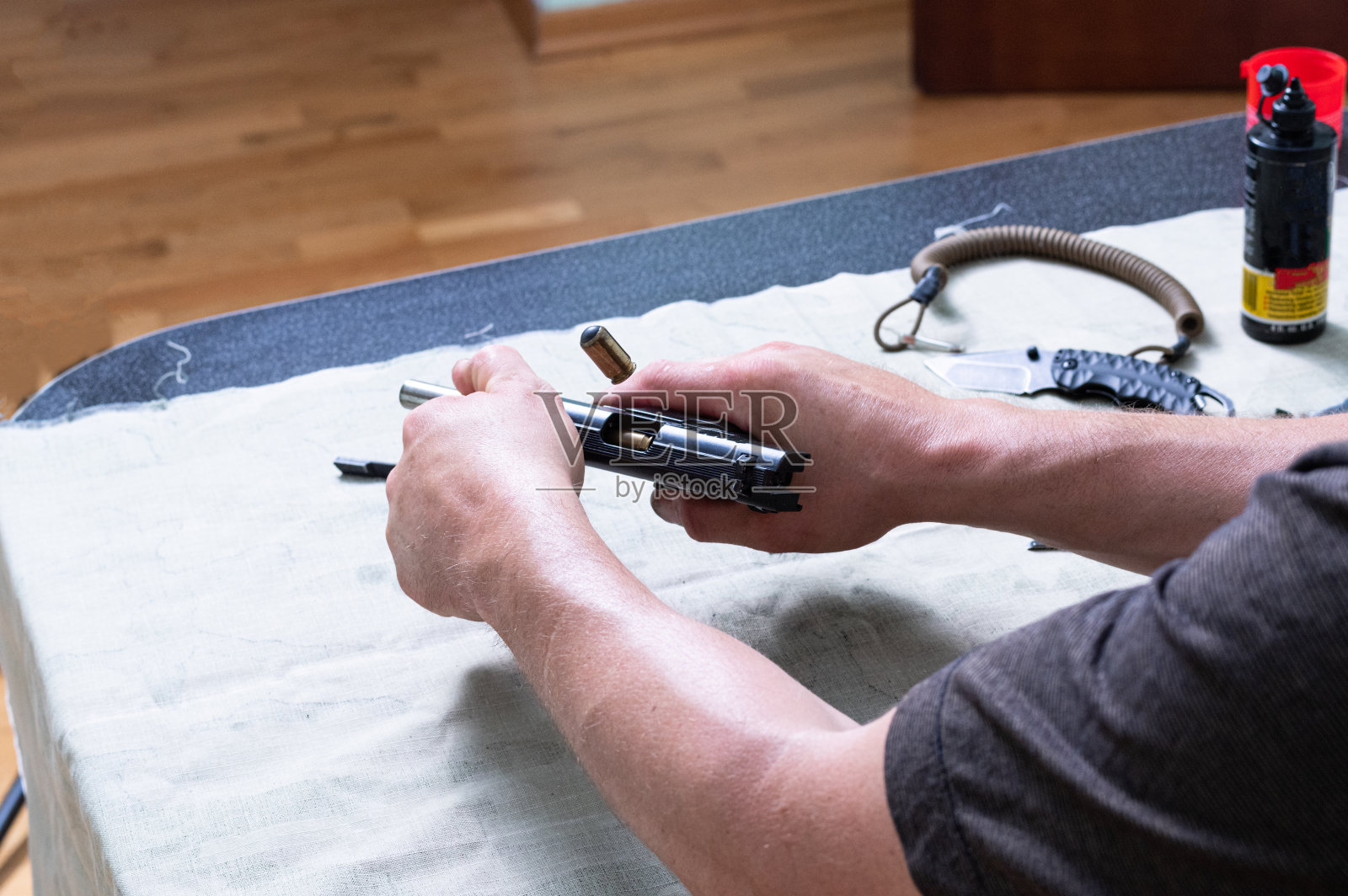 重新加载一个手枪。子弹从手枪弹夹中射出的飞行手里拿着手枪。子弹从枪里射出。房子的武器。照片摄影图片