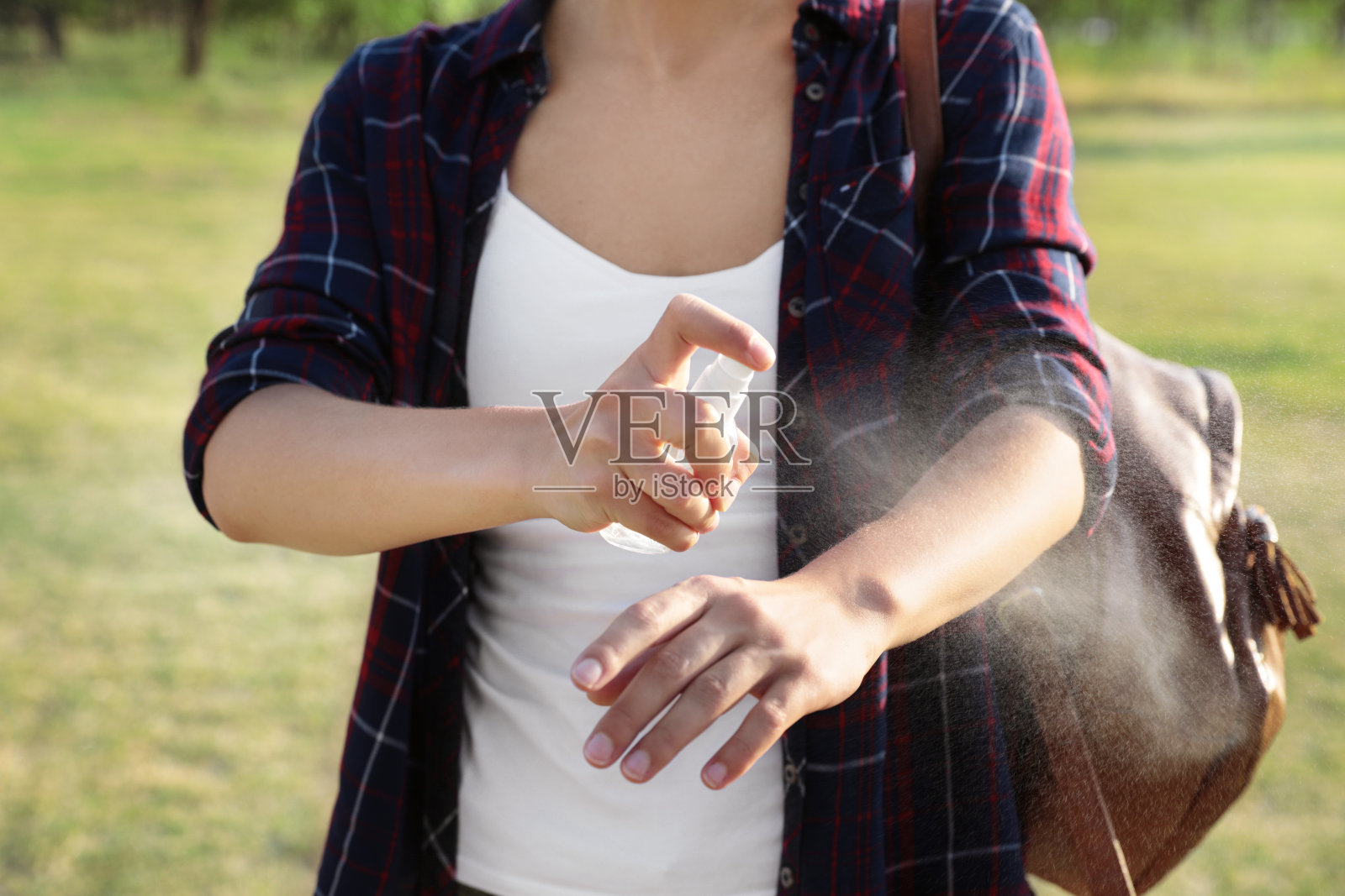 户外妇女在手臂上涂驱虫剂，特写镜头照片摄影图片