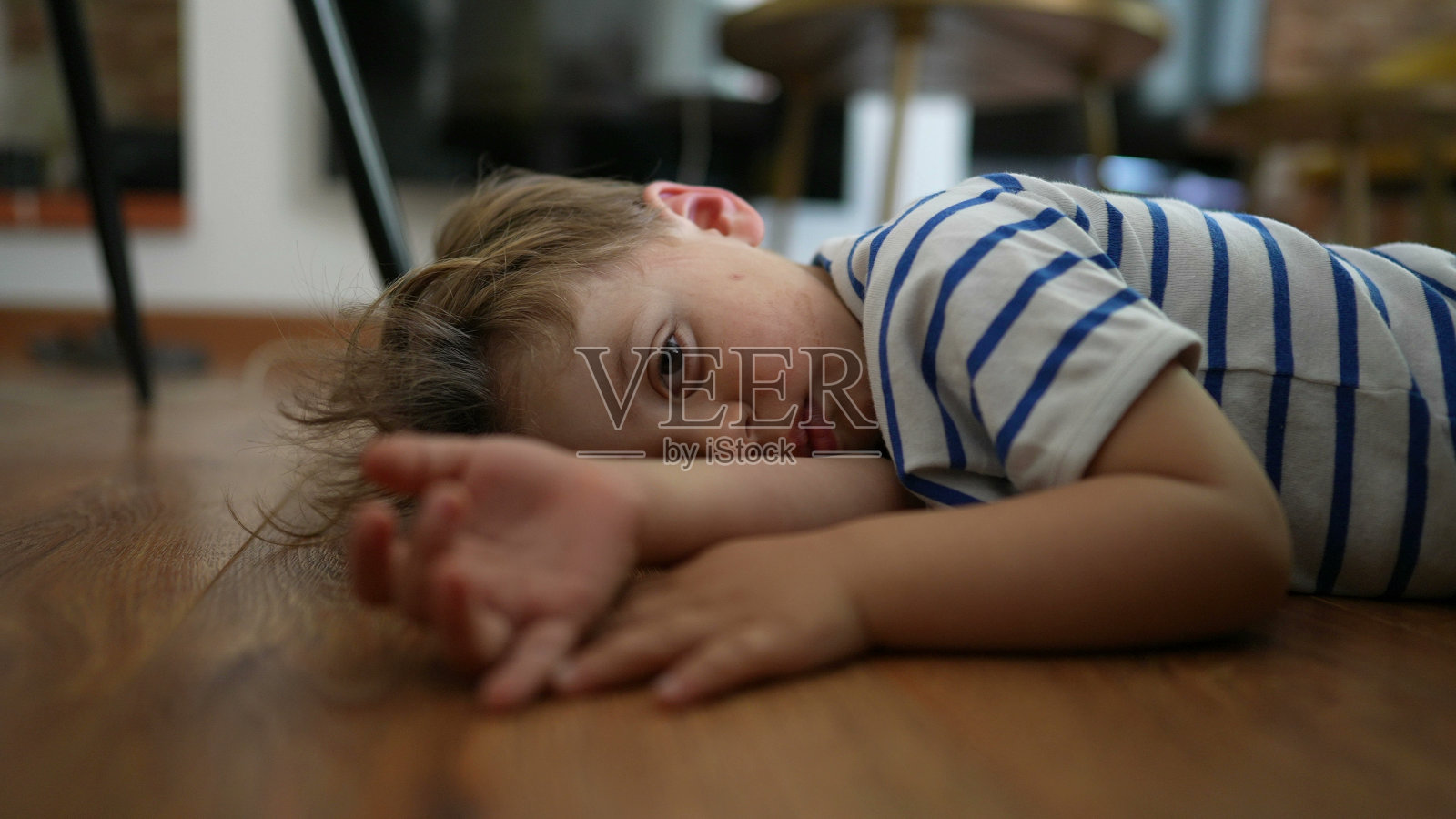 无聊的孩子躺在家里的地板上无事可做，感到无聊照片摄影图片