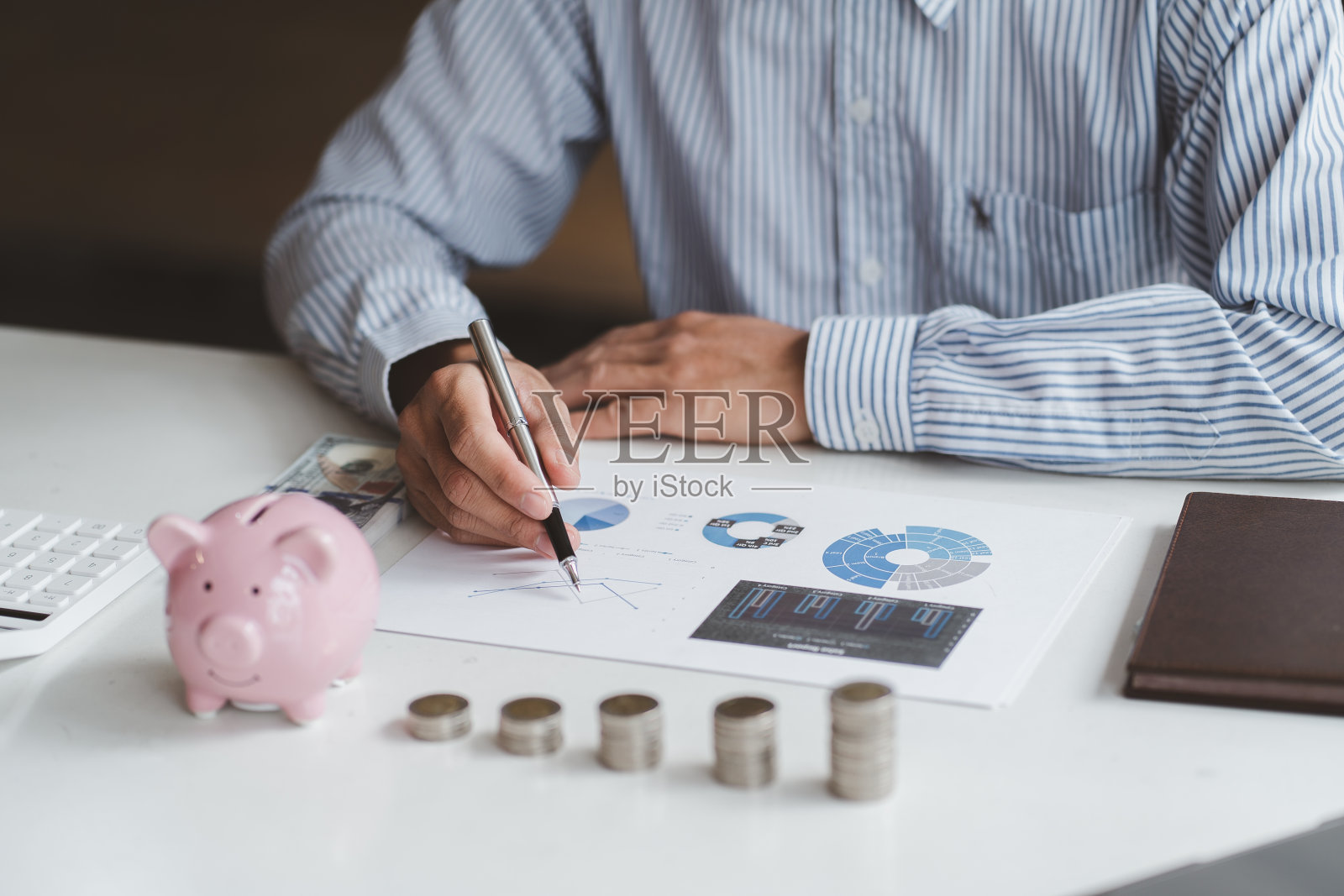 商业人士计划财务报表与存钱罐和硬币，投资和财务概念。照片摄影图片