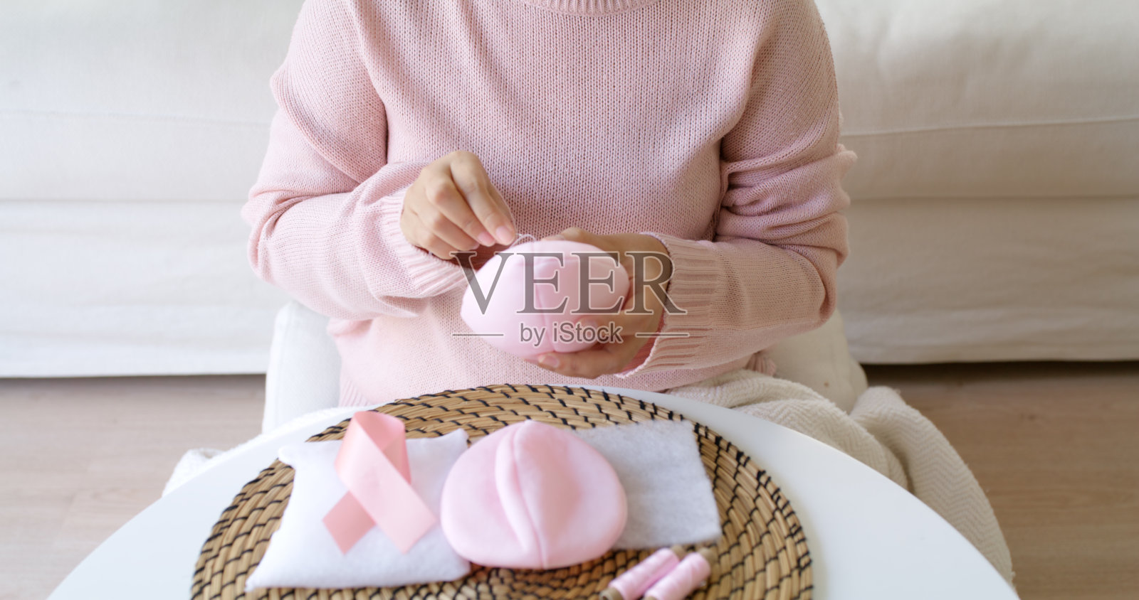 近手亚洲妇女帮助使工艺粉红色单填补胸罩杯插入后乳房切除术假体手术在家。救灾服务支持给肿瘤患者医疗问题带来希望。照片摄影图片