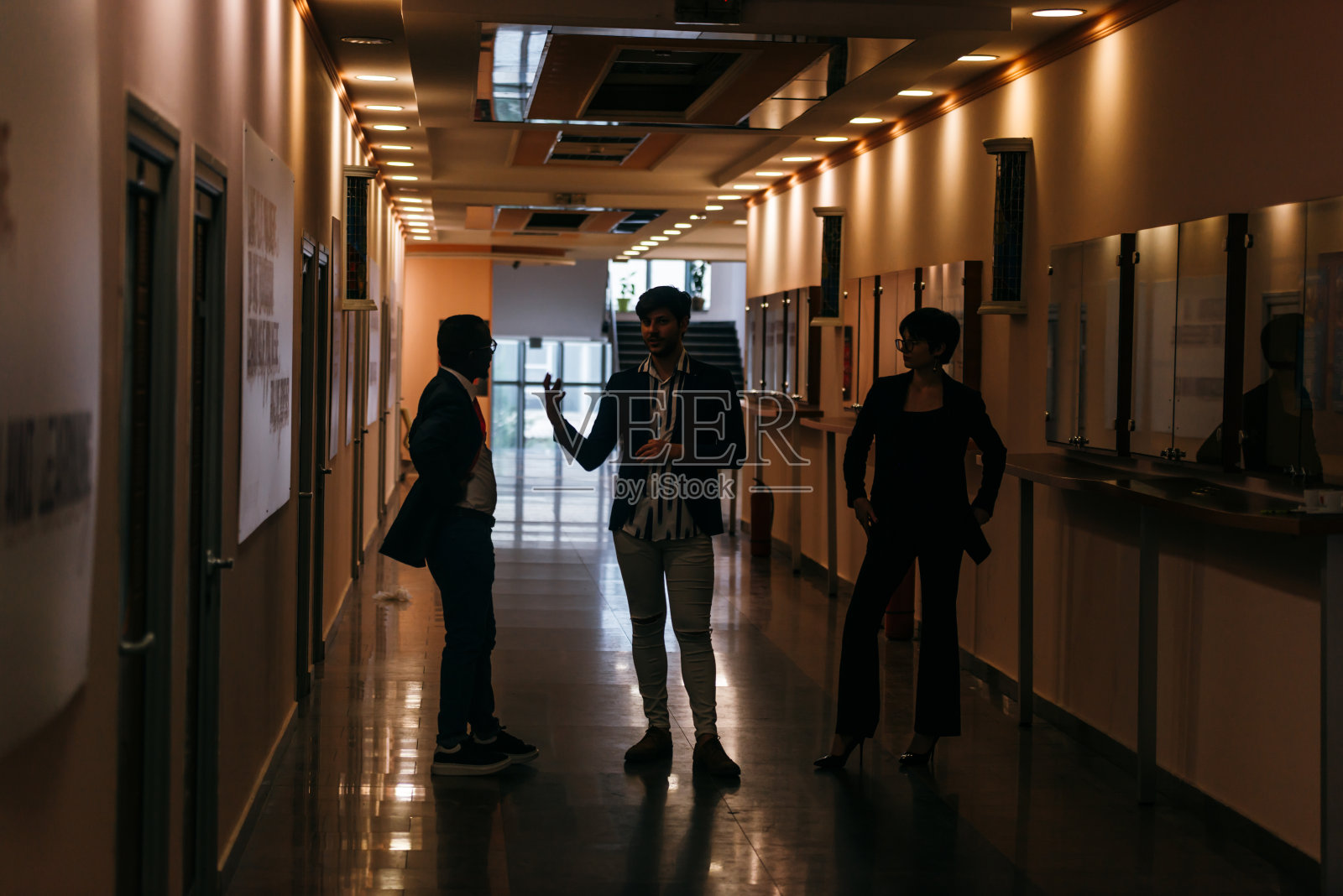 商务人士站在公司大楼里的剪影。照片摄影图片