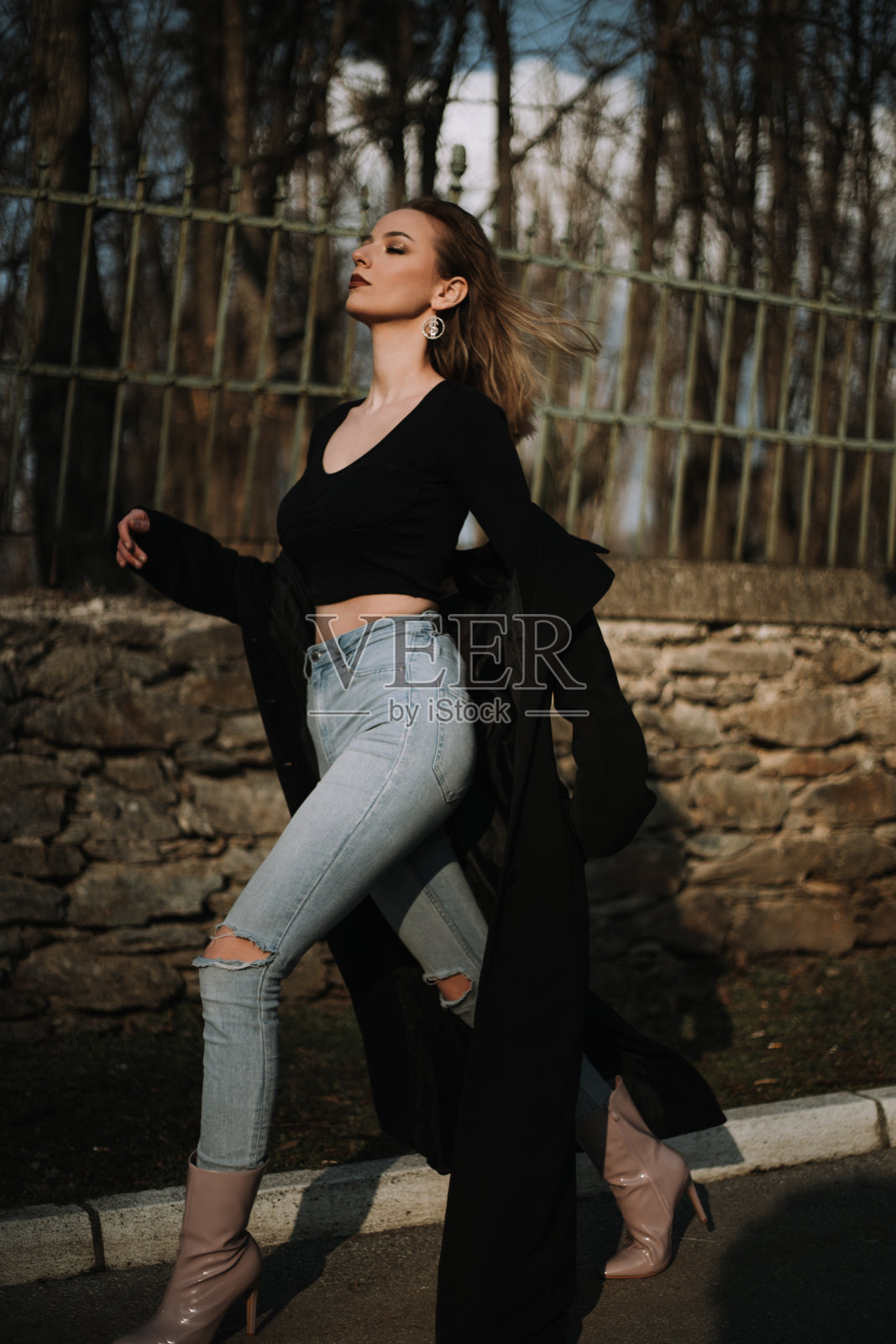 穿着黑色外套的漂亮年轻女人走在街上照片摄影图片