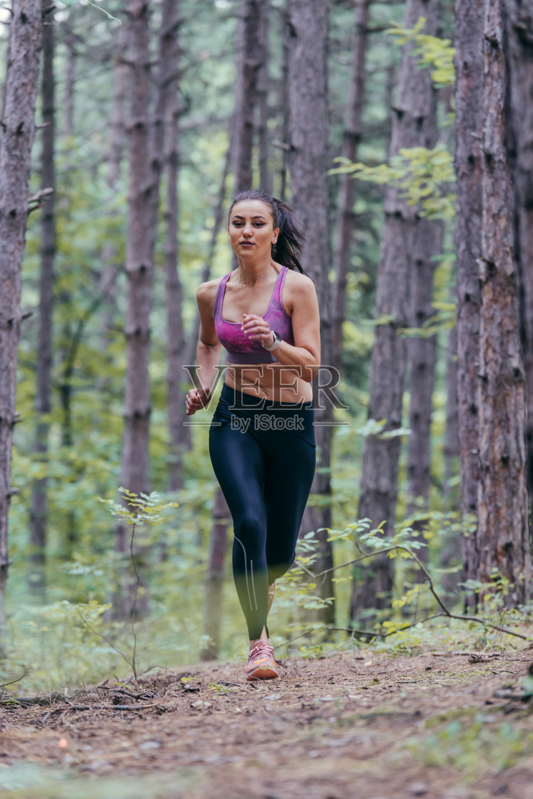 一个年轻的运动女孩正在外面的森林小路上慢跑照片摄影图片
