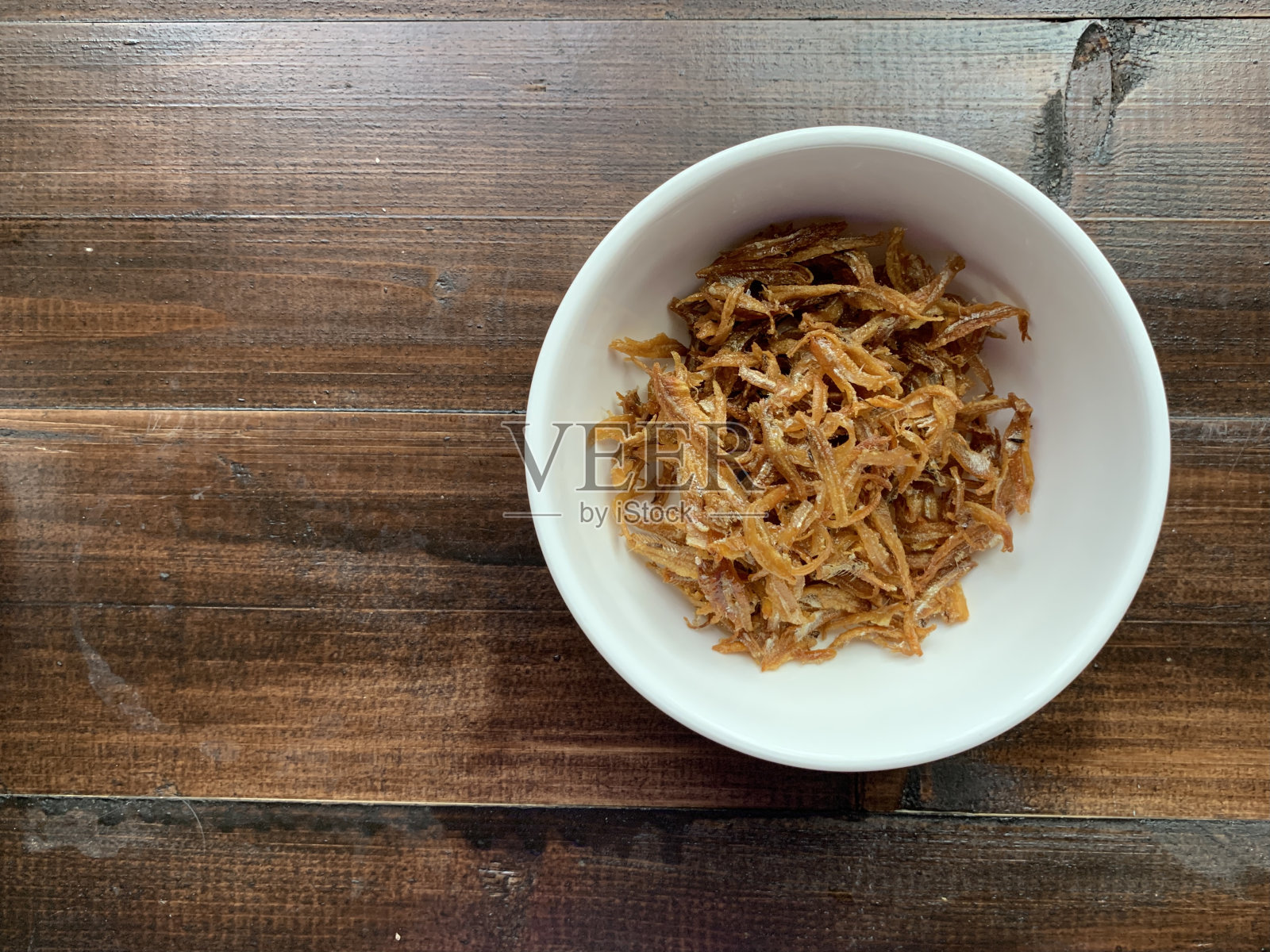 在碗里炸凤尾鱼。照片摄影图片