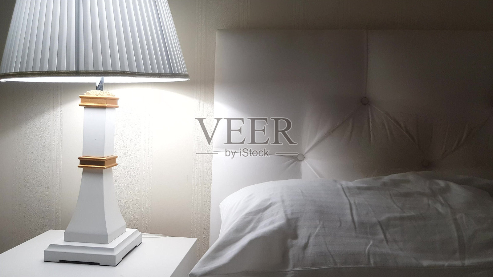 豪华酒店床，准备睡觉，床头柜上有台灯和干净的白色床单，床上有枕头，晚上照片摄影图片