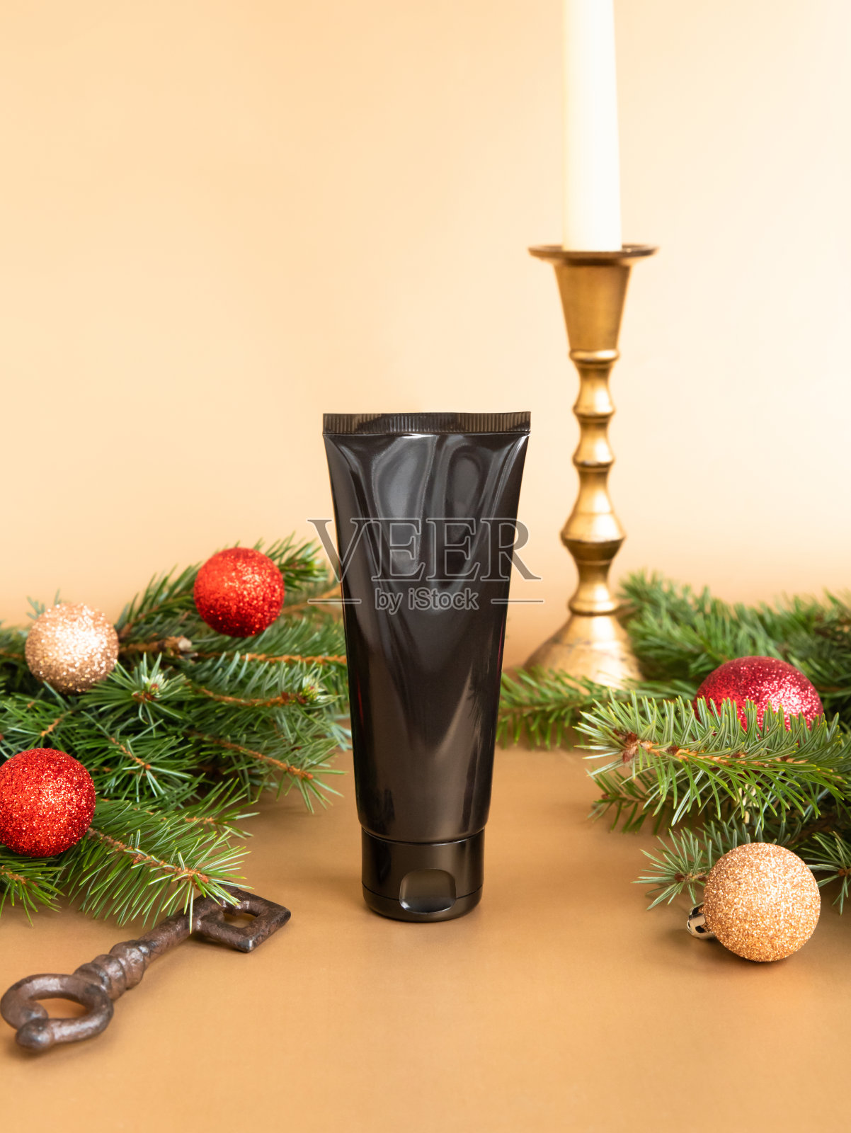 黑美水疗医疗护肤和化妆品乳液瓶管霜包装产品，圣诞冷杉树，闪亮球，金色烛台和金色背景的钥匙。前视图，模型，模板。照片摄影图片