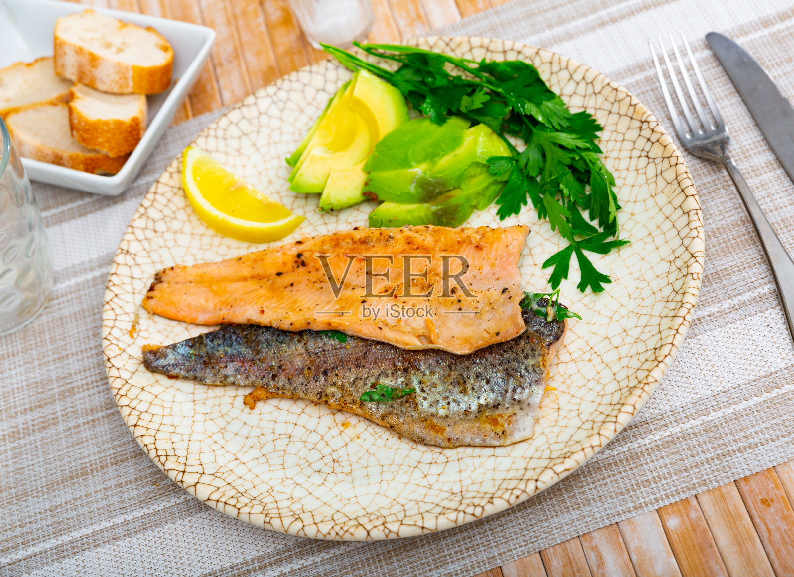 盘子与油炸鳟鱼片与鳄梨在餐厅特写照片摄影图片