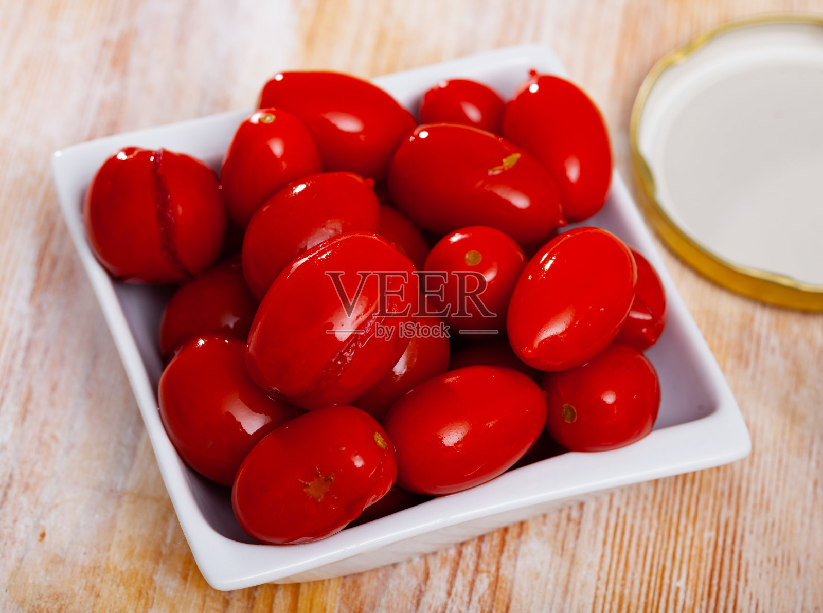 红色的腌番茄在盘子特写。保持新鲜照片摄影图片