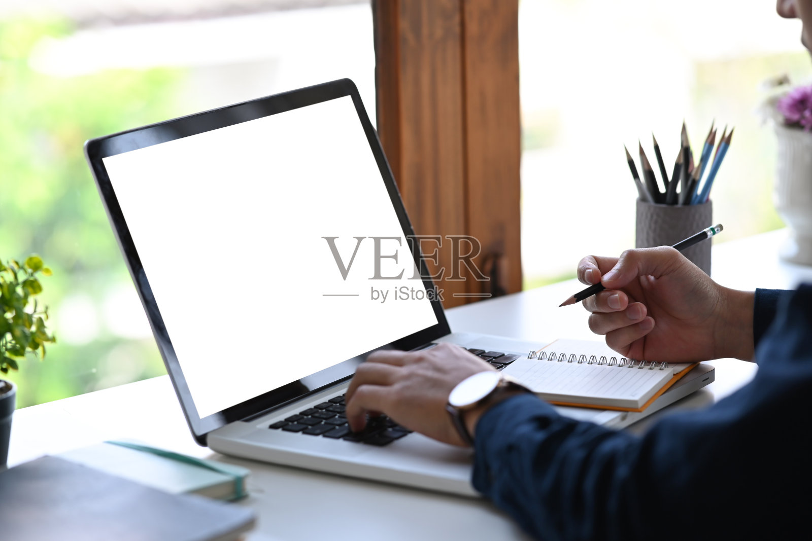 裁剪镜头商人工作与笔记本电脑和笔记的笔记本。照片摄影图片