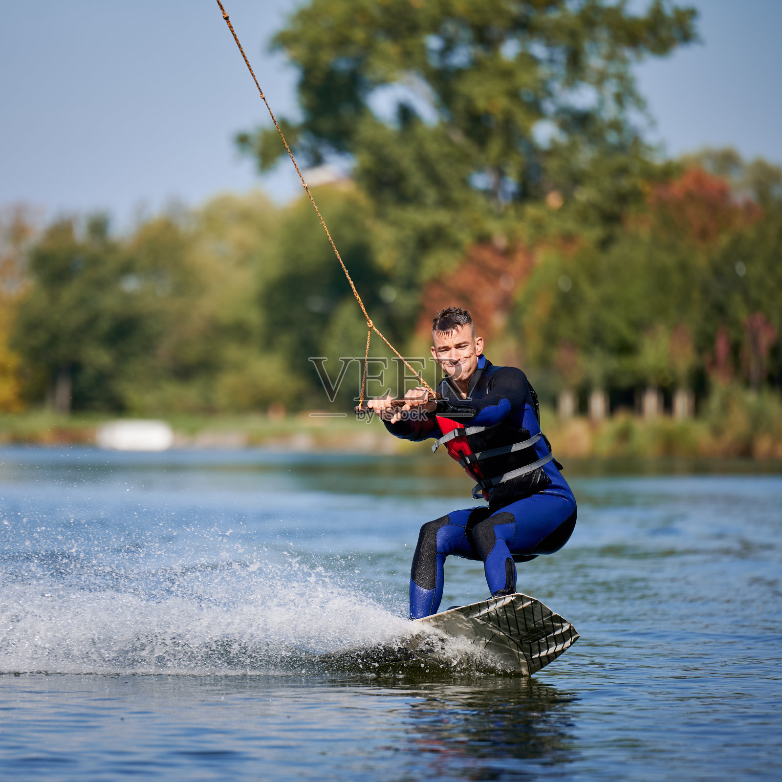 年轻的冲浪者在缆车公园玩滑水橇。照片摄影图片
