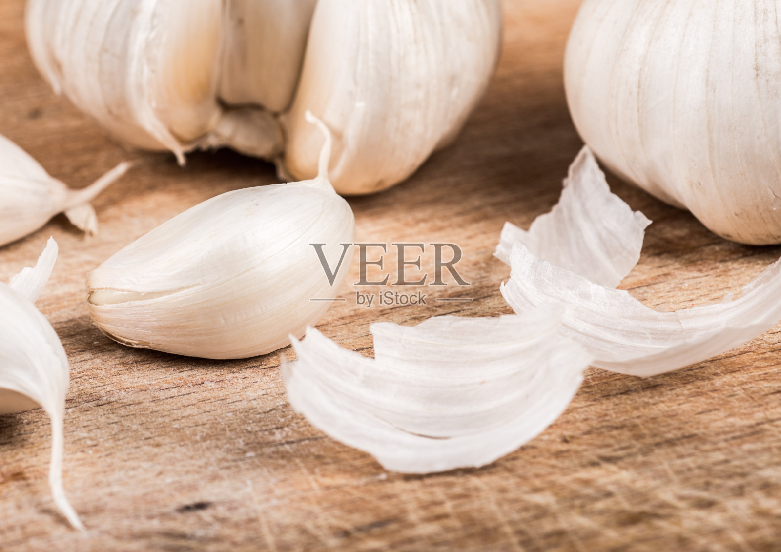 大蒜放在木板上，背景是厨房用具照片摄影图片