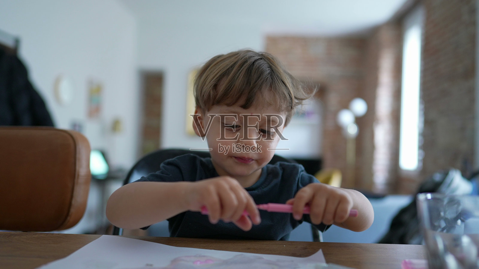 用彩笔在纸上画画的小男孩在玩工艺品照片摄影图片
