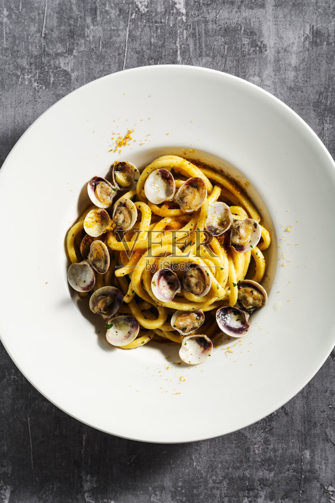混凝土表面上新鲜的自制意大利面，配上蛤蜊和鱼子酱照片摄影图片