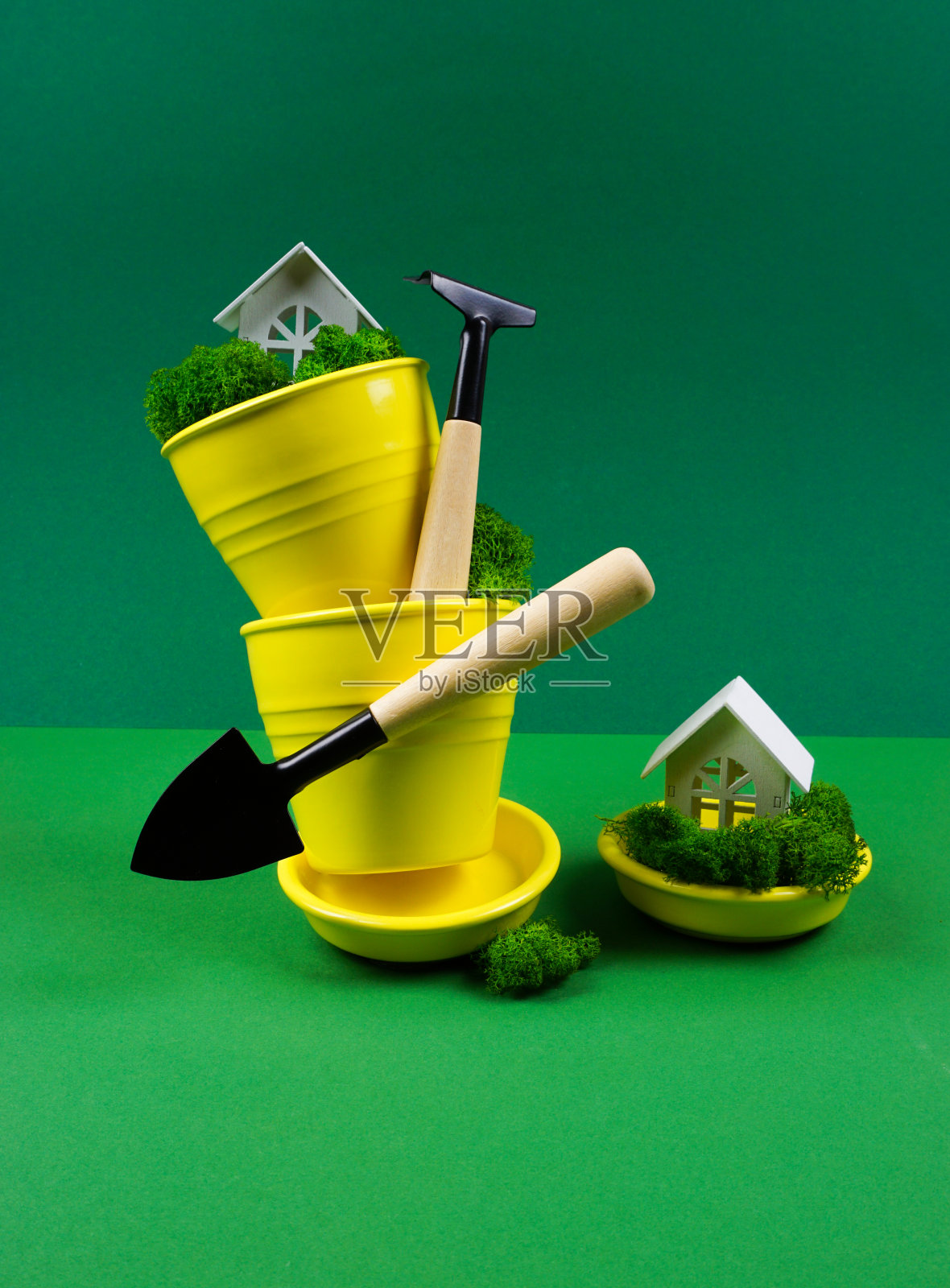 创造性的照片在绿色的背景与黄色的花盆和花园工具照片摄影图片