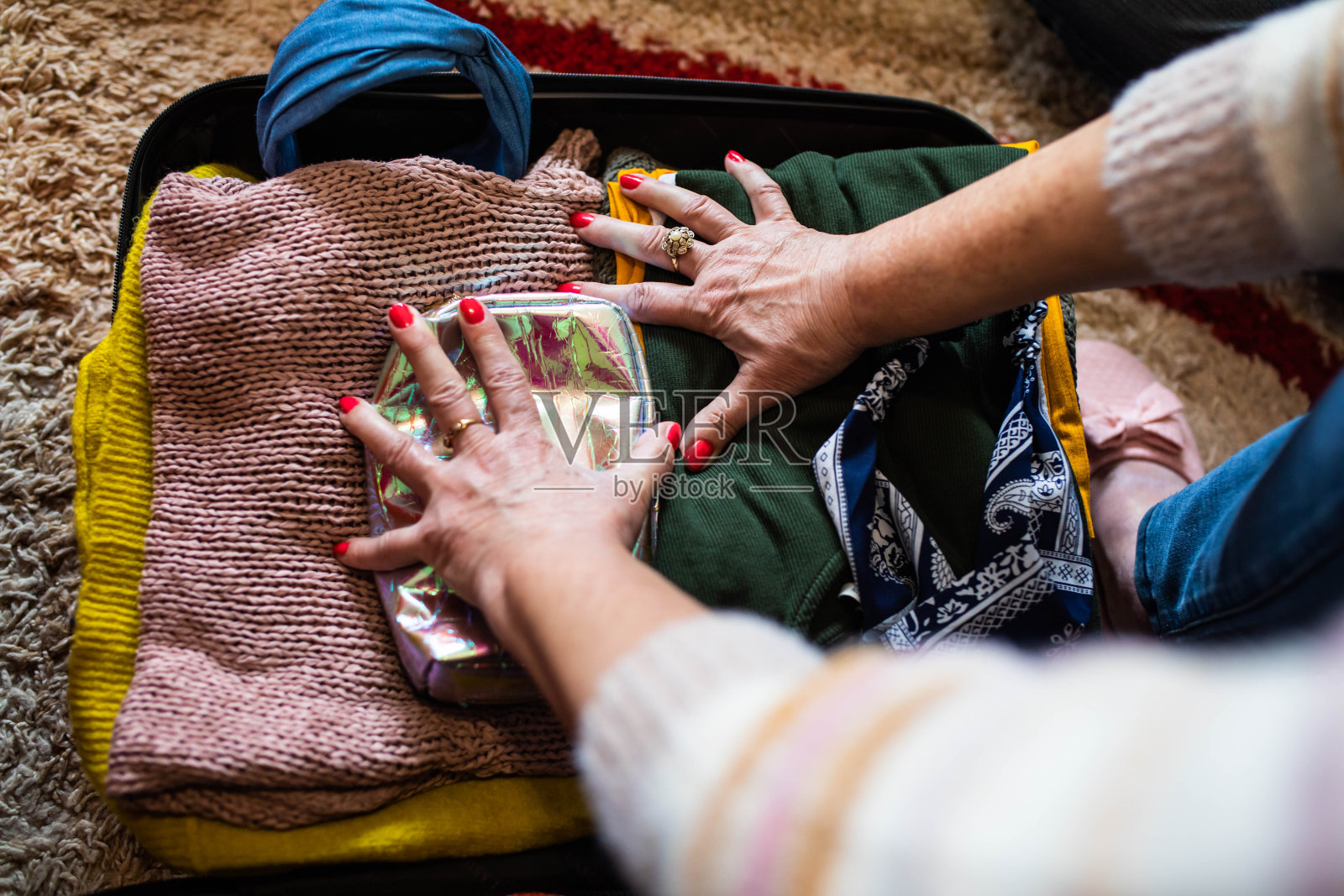 一个成熟女人的手在整理她的行李箱照片摄影图片