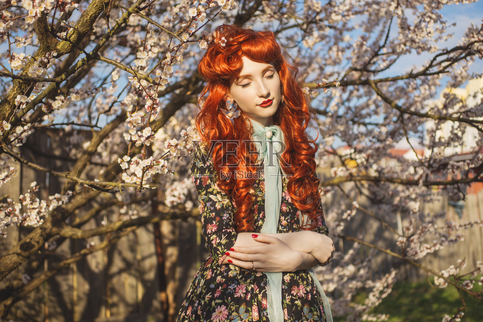 日常生活的简单享受。情人节的背景。迷人的红发模特享受阳光灿烂的日子。健康和自我保健。一个女人在花园里闻着盛开的花。欣赏和喜悦的感觉。照片摄影图片