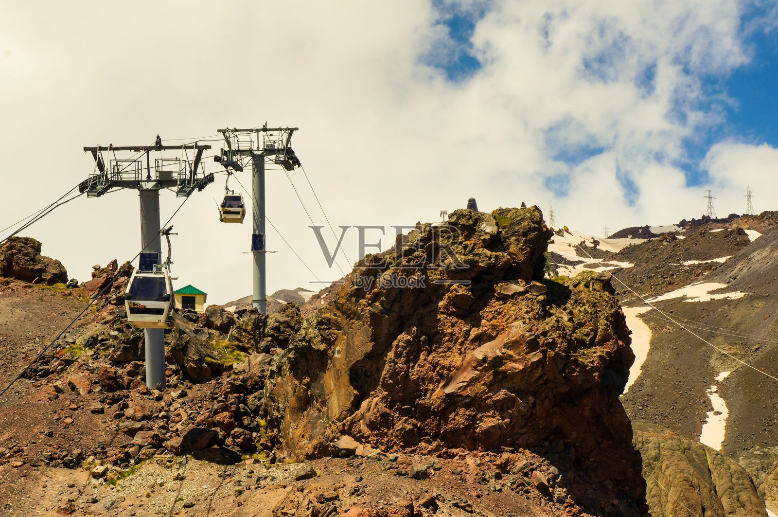 在天空和云彩的背景下，贡多拉载着人们登上高山。活跃的冬季休闲的概念。缆车照片摄影图片