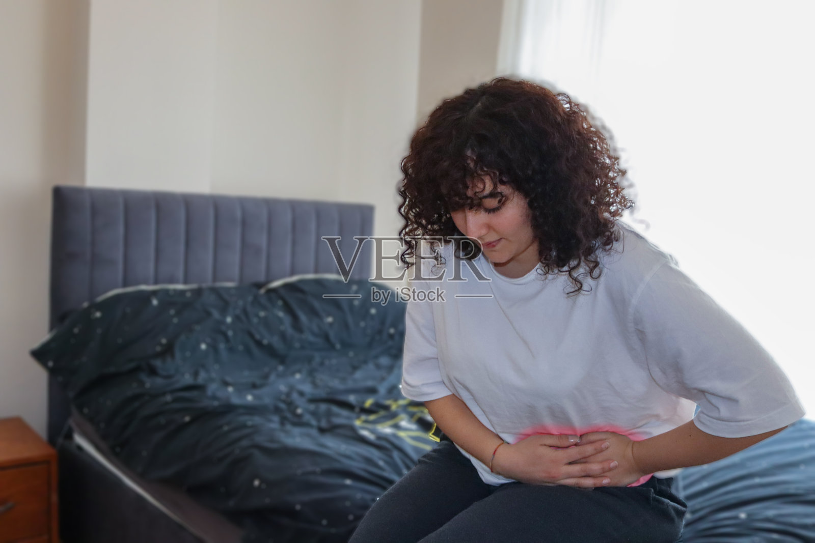 一个胃痛的年轻女孩照片摄影图片