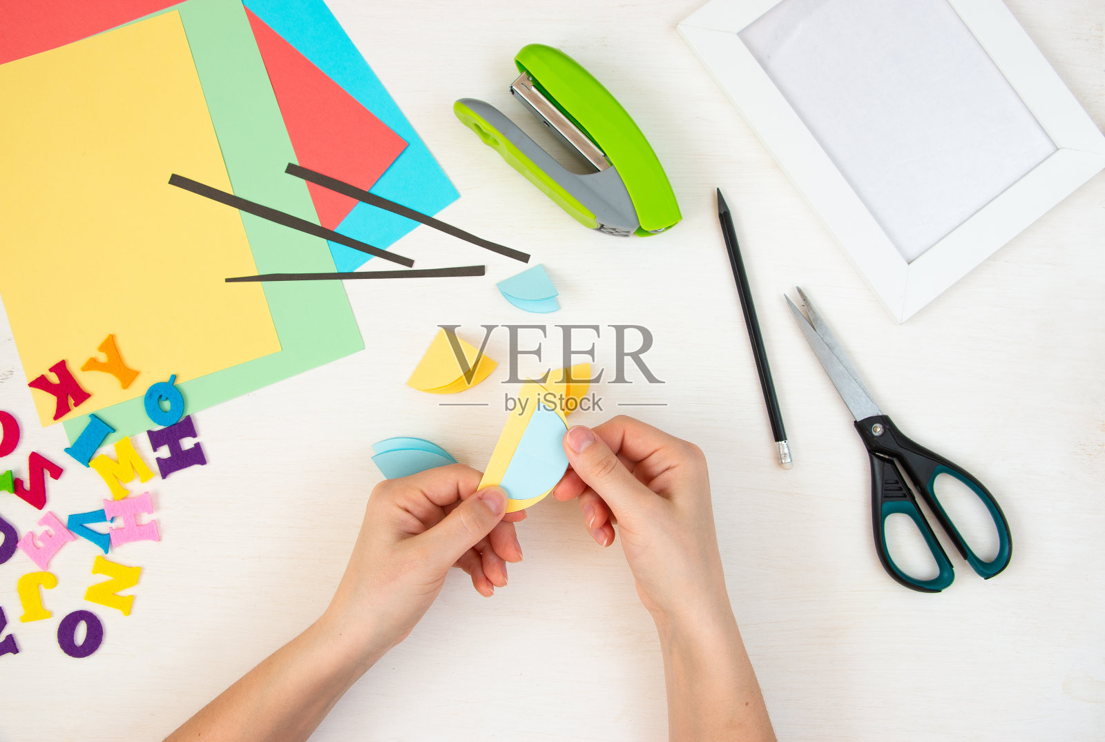 女人的手折叠彩色的纸圈。一步一步的说明，俯视图。步骤11。照片摄影图片