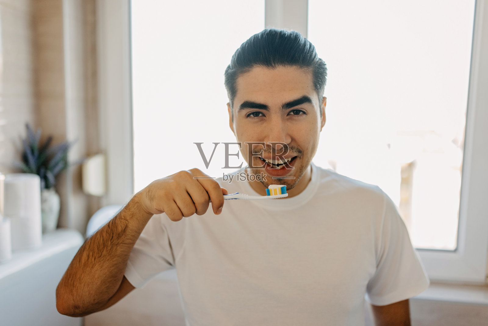 年轻的拉丁男子在刷牙照片摄影图片