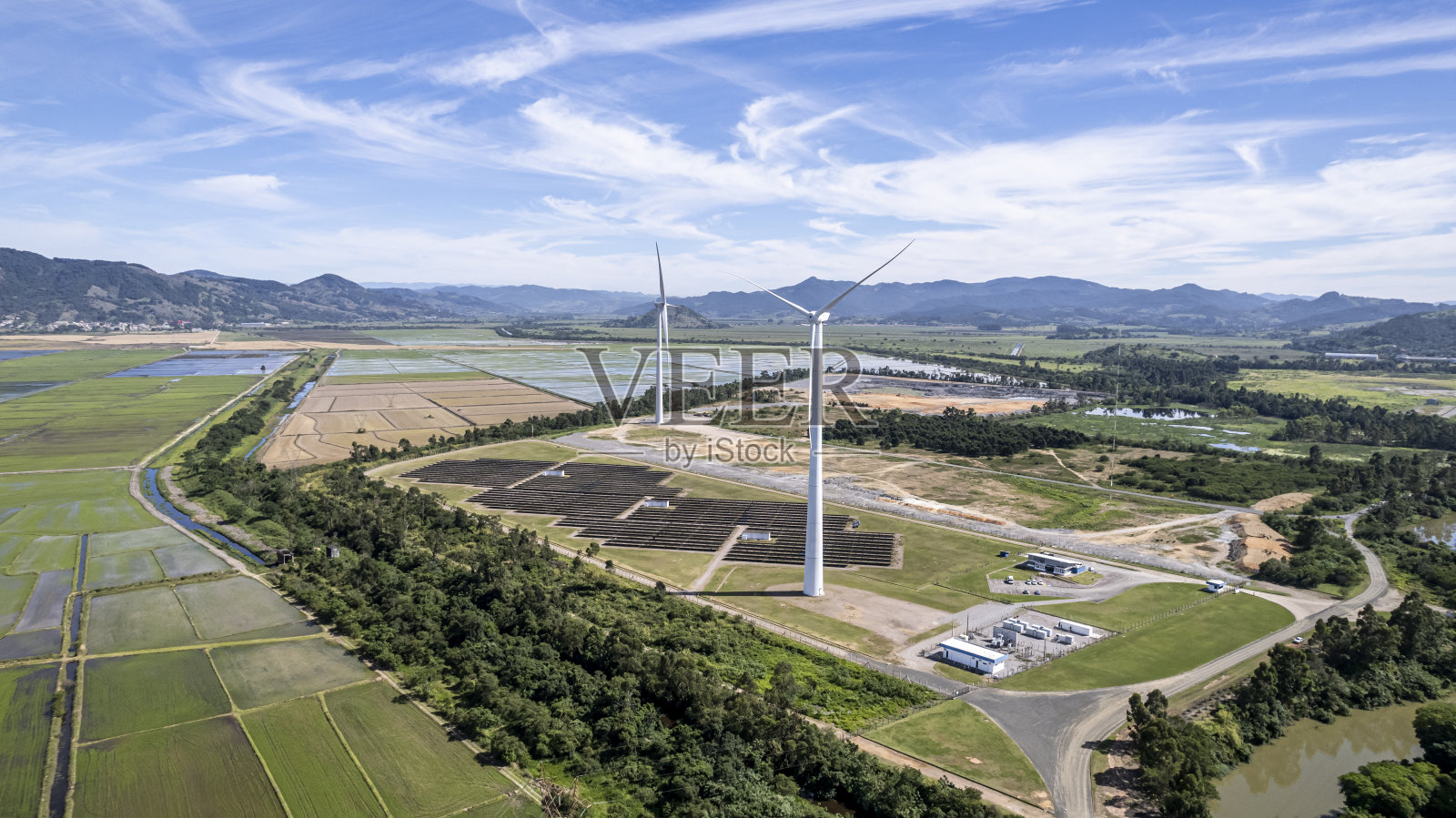 在一个中等规模的城郊地区建一个带有太阳能电池板的风电场照片摄影图片