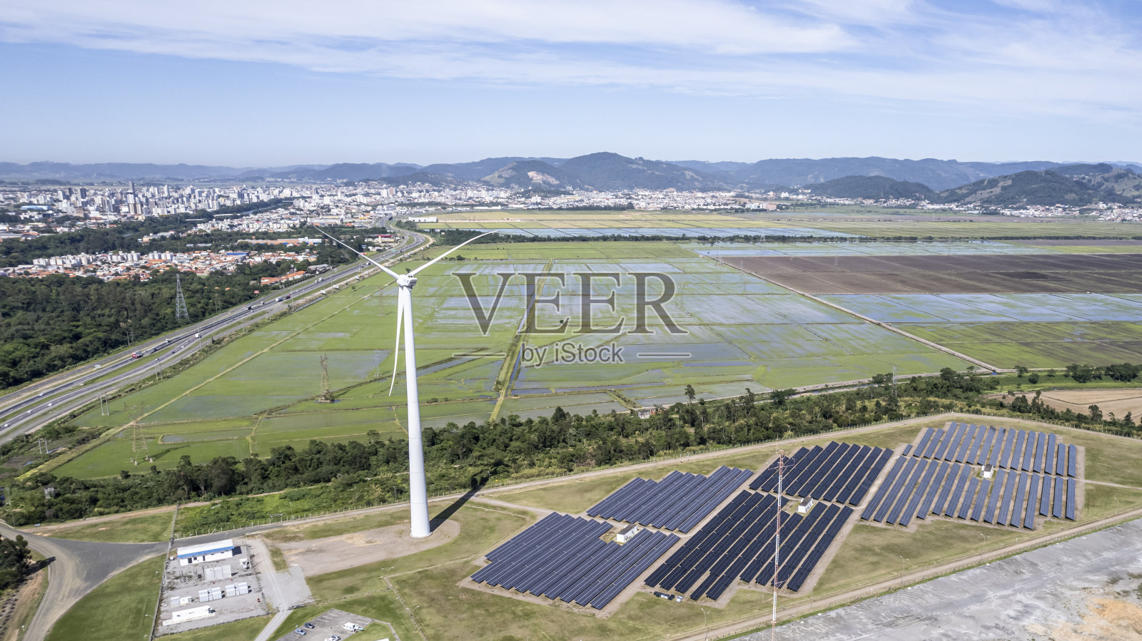 在一个中等规模的城郊地区建一个带有太阳能电池板的风电场照片摄影图片