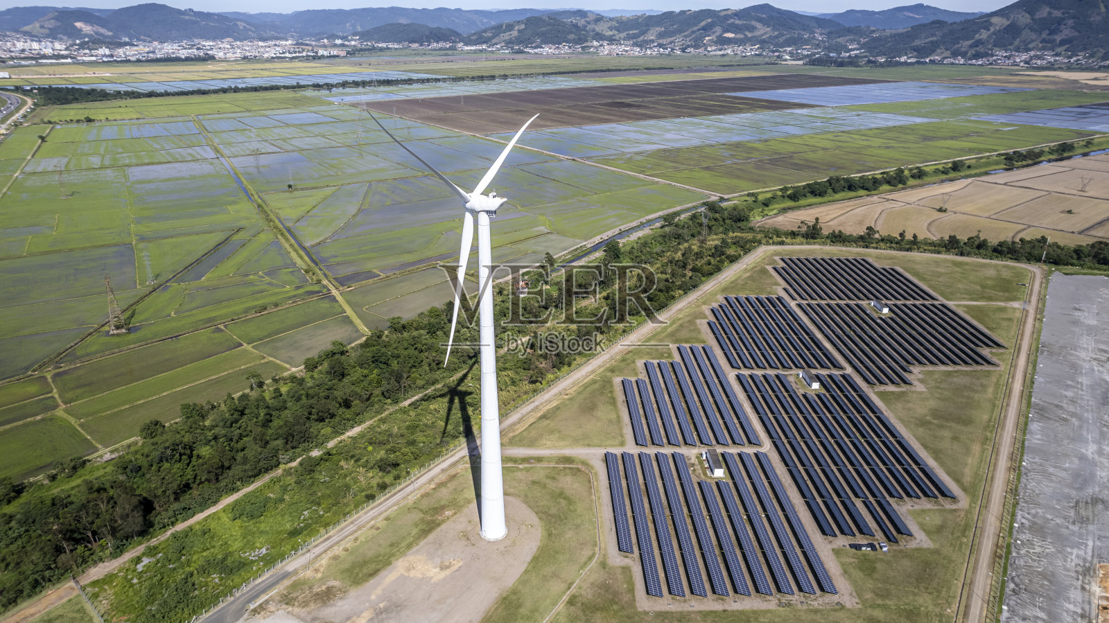 在一个中等规模的城郊地区建一个带有太阳能电池板的风电场照片摄影图片