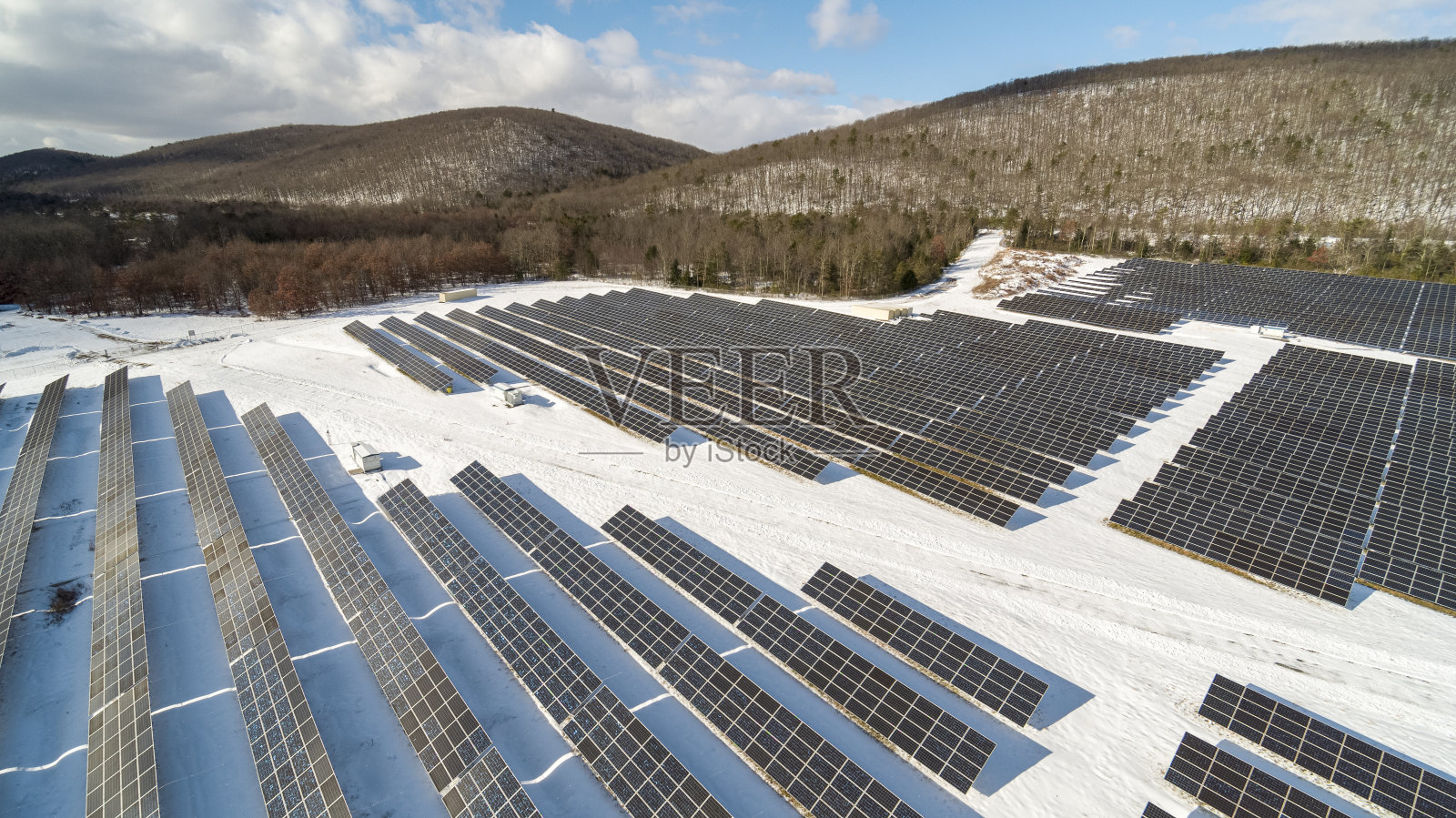 宾夕法尼亚州阿巴拉契亚山脉的大型太阳能农场，在一个阳光明媚的冬日里，一场大雪过后。照片摄影图片