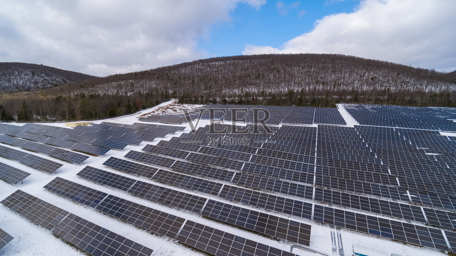 宾夕法尼亚州阿巴拉契亚山脉的大型太阳能农场，在一个阳光明媚的冬日里，一场大雪过后。照片摄影图片