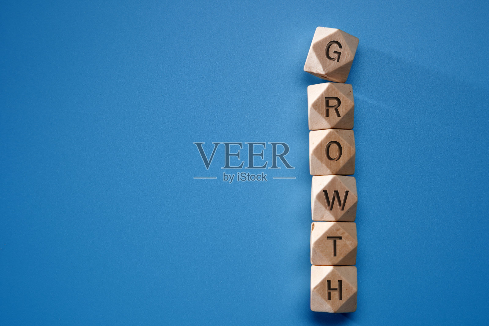 木制玩具积木，黄色墙壁上有一个单词生长和红色箭头符号。照片摄影图片