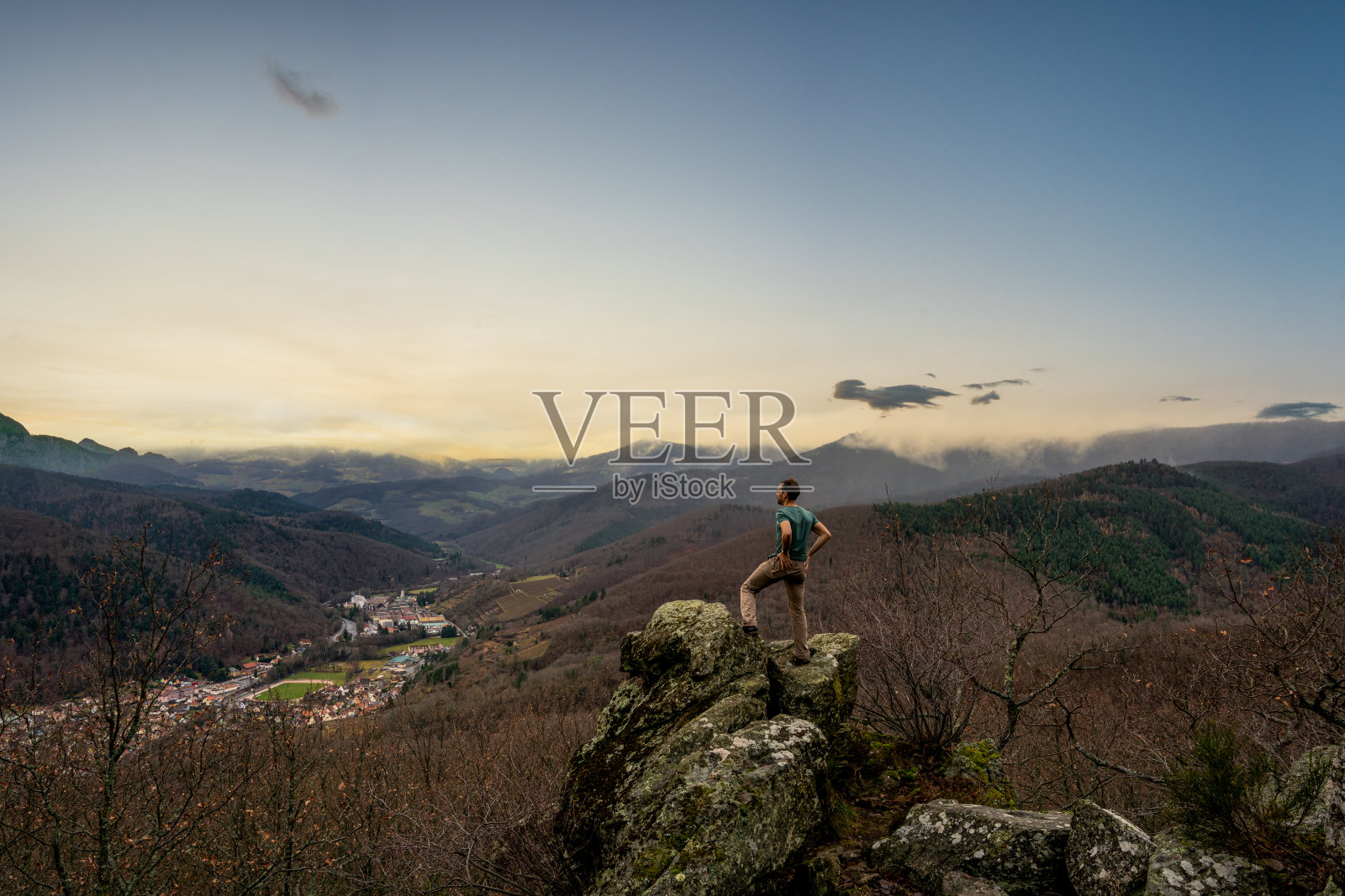 一个人站在低山脉的岩石上照片摄影图片