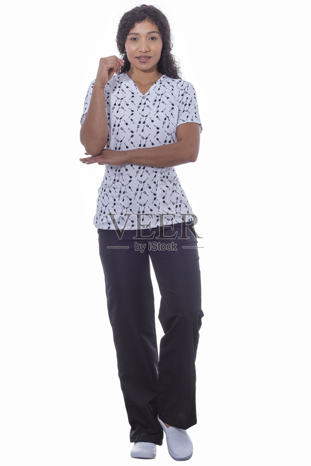 美丽的女人穿着他的美容制服，而在美容工作室照片摄影图片