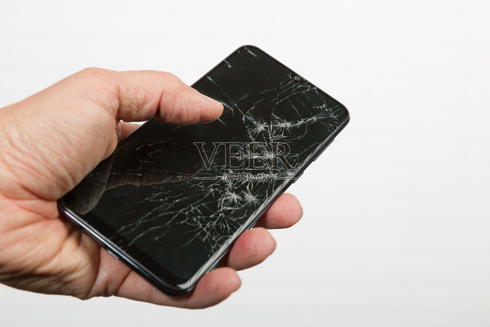 Hand展示了一个显示屏坏掉的智能手机照片摄影图片