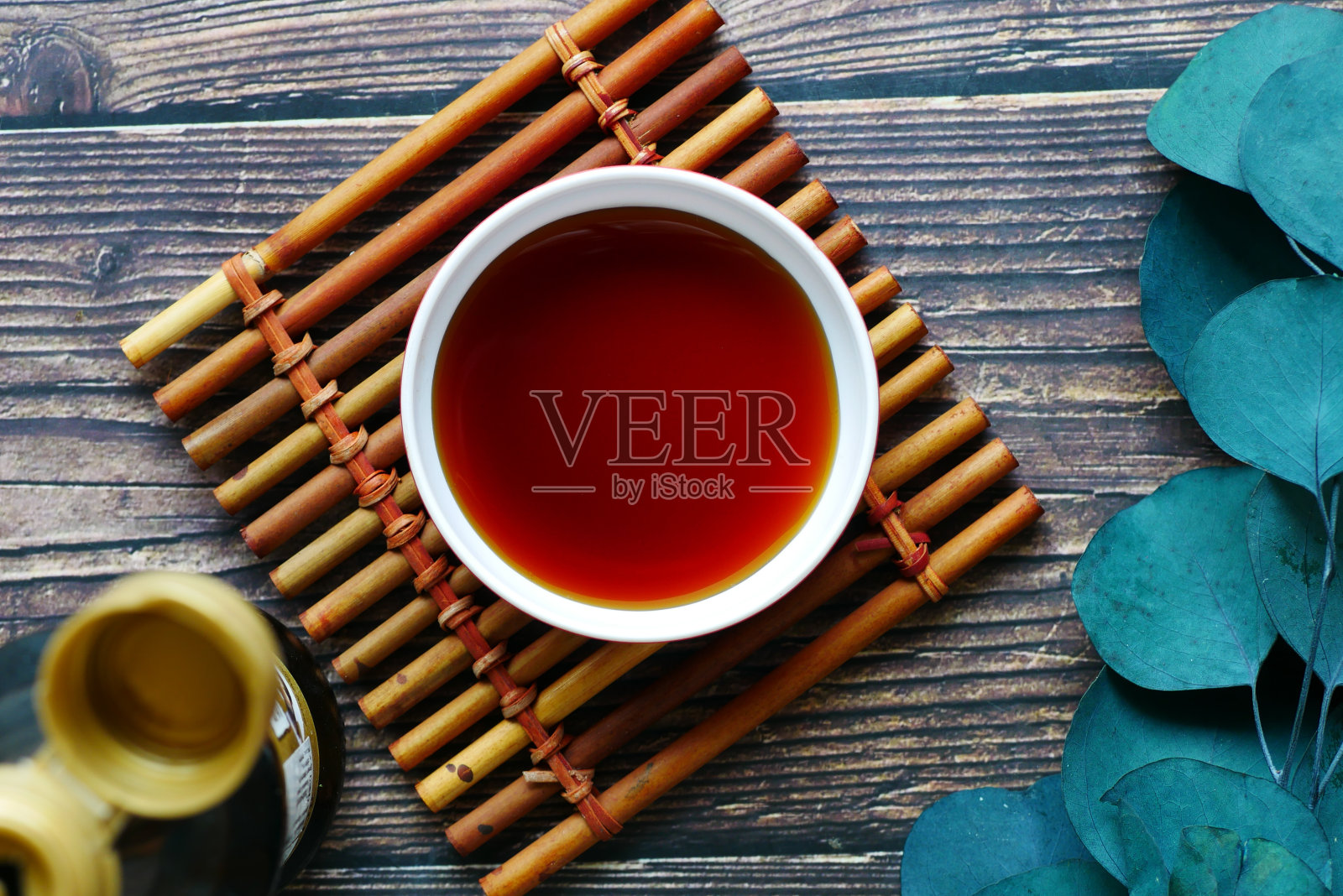 酱油在一个容器与叶木制背景照片摄影图片
