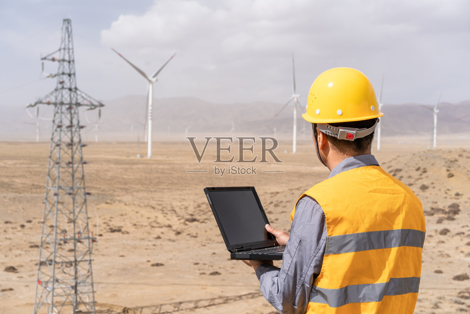 亚洲男性电力工程师在风力发电站工作照片摄影图片