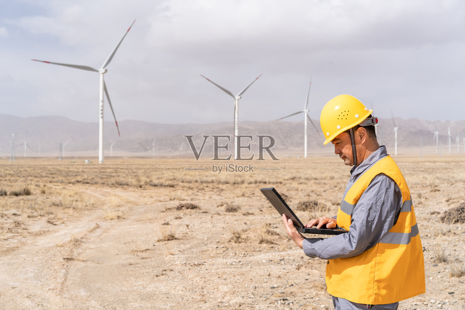 亚洲男性电力工程师在风力发电站工作照片摄影图片