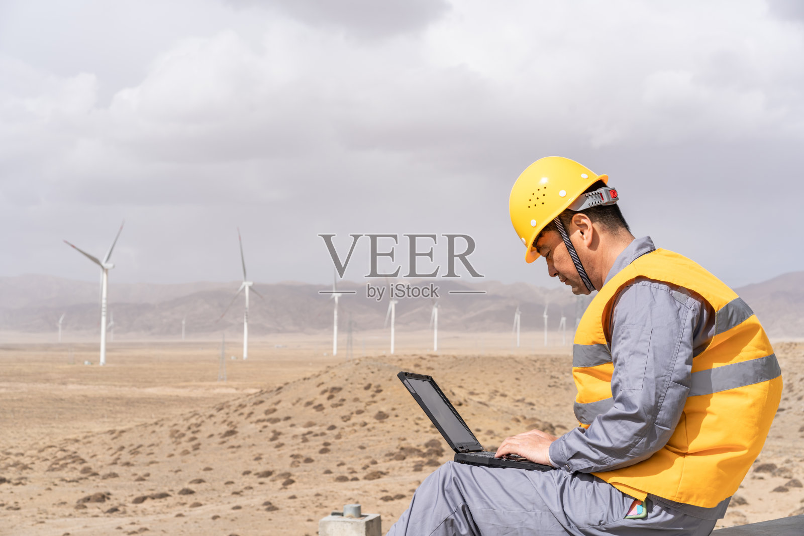 亚洲男性电力工程师在风力发电站工作照片摄影图片