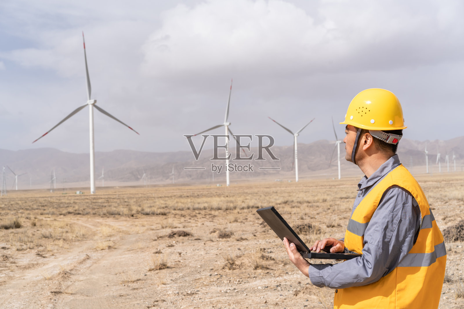 亚洲男性电力工程师在风力发电站工作照片摄影图片