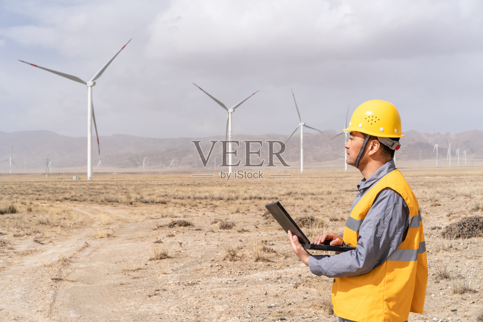 亚洲男性电力工程师在风力发电站工作照片摄影图片