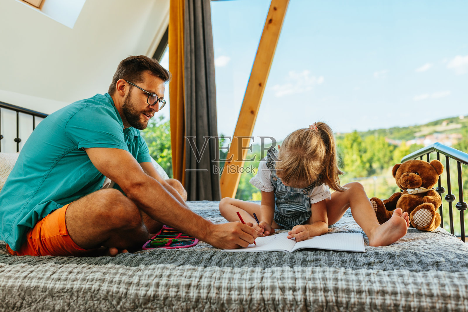 全神贯注的父亲和学龄前的女儿在纸上画画照片摄影图片