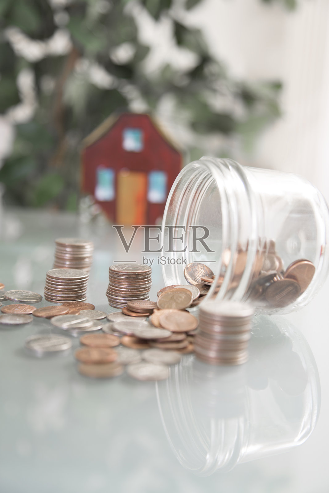 新屋建筑。漆过的木块构成了一所房子。装着硬币的玻璃罐可以用来买房子。照片摄影图片