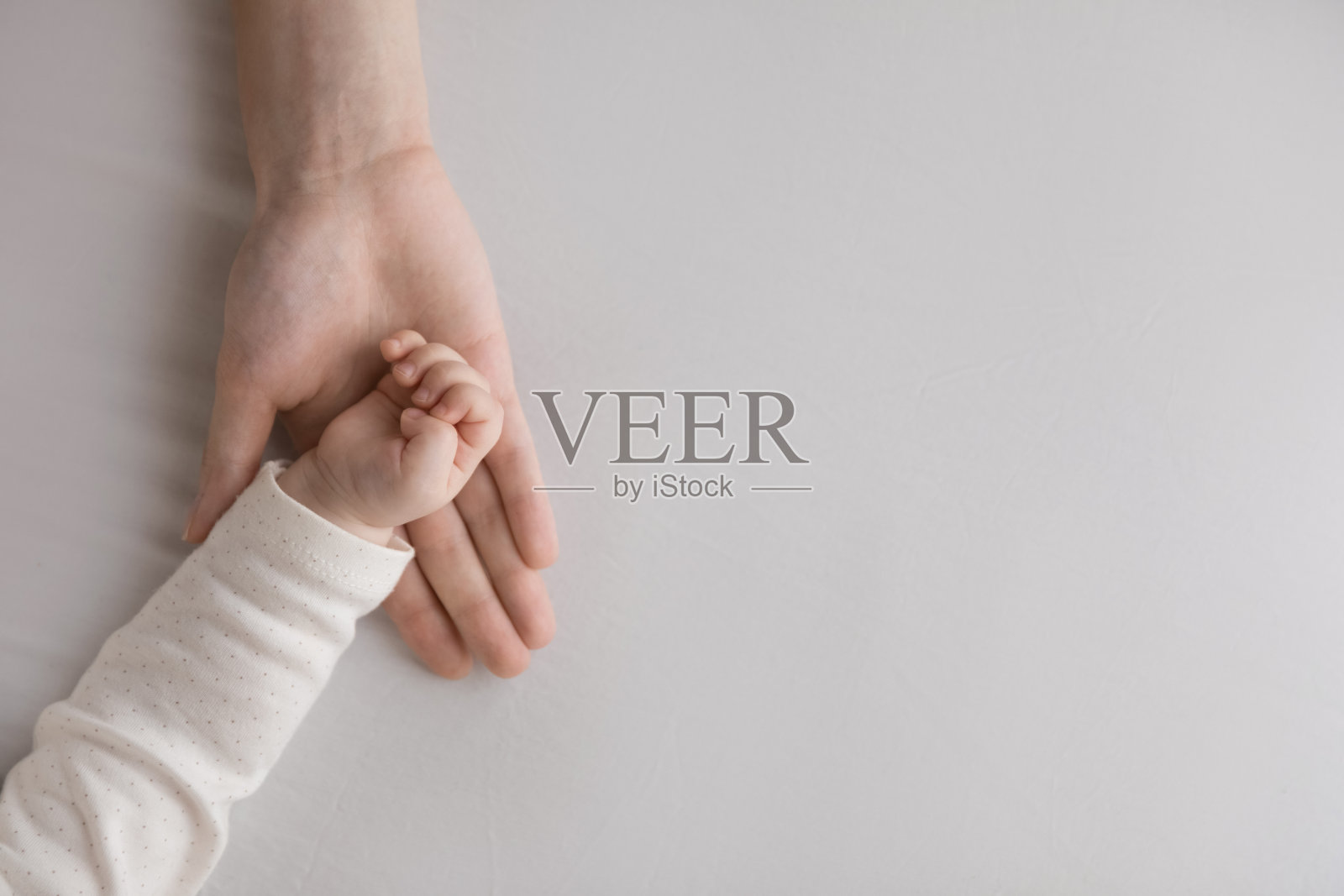 甜蜜的几个月婴儿的手休息在母亲的手掌照片摄影图片